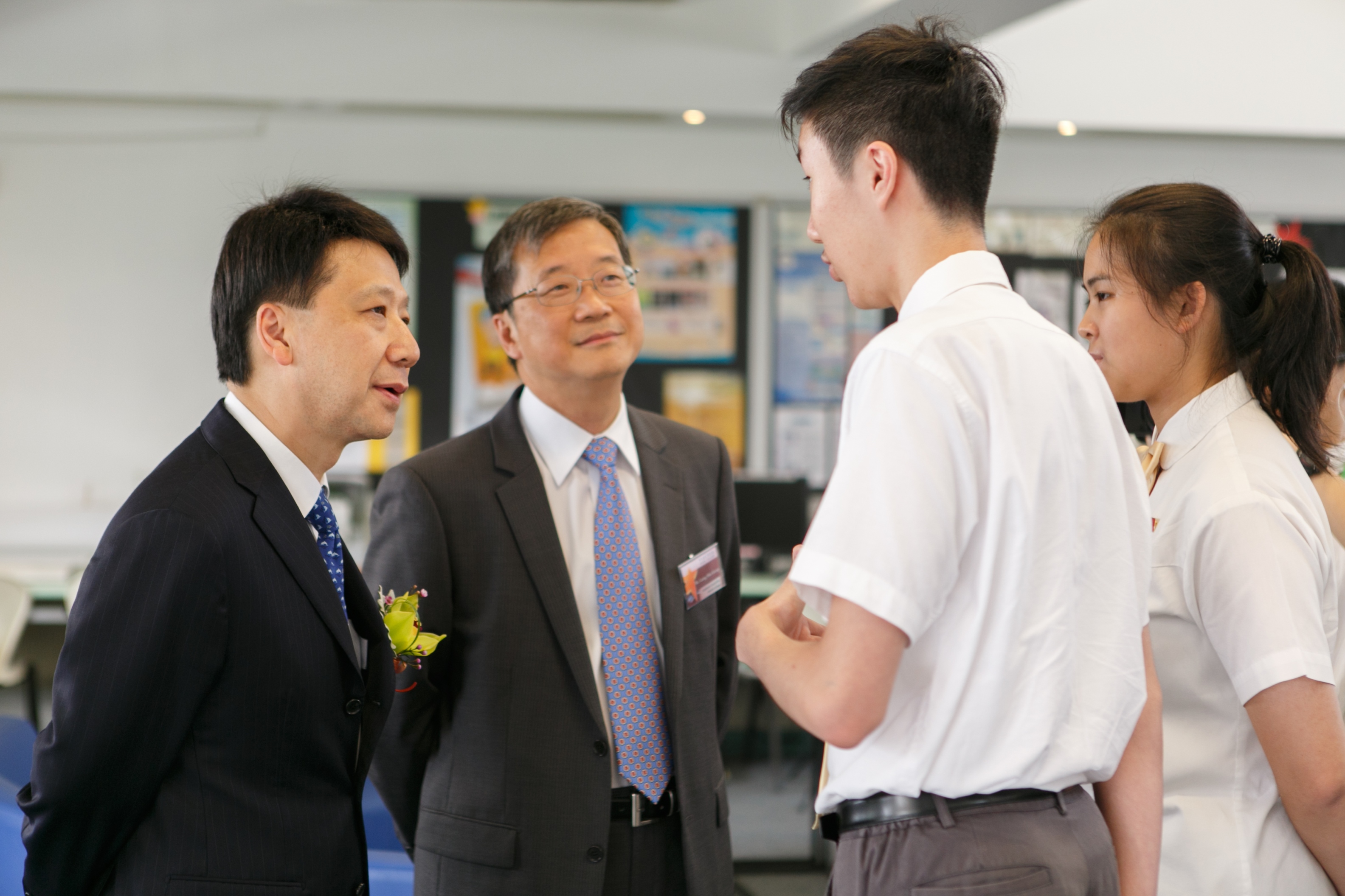 Mr. Pang Yiu Kai, SBS, JP (on the left) talking with students.